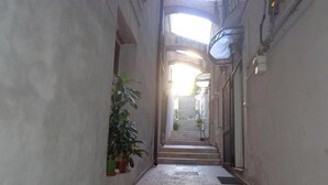 Un corridoio stretto con una scalinata in marmo che conduce a un livello superiore.