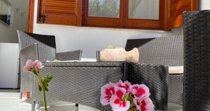 A wicker outdoor seating area with a table, chairs, and a potted plant. - Holiday Home 'Maltese' with Shared Terrace, Wi-Fi & Air Conditioning (San Vito Lo Capo)