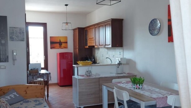 A compact living space with a kitchenette, a dining area, and a sofa. - Casa Concettina: Mountain View, Balcony & Air Conditioning (San Vito Lo Capo)
