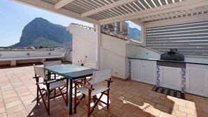 A rooftop patio with a table and chairs, a pergola, and a view of a mountain. - Holiday Home 'Berta' with Sea View, Private Terrace and Air Conditioning (San Vito Lo Capo)