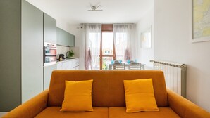Ein modernes Wohnzimmer mit einer Couch und Blick auf einen Essbereich.