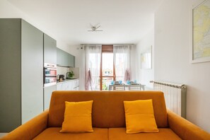 Ein modernes Wohnzimmer mit einer Couch und Blick auf einen Essbereich.