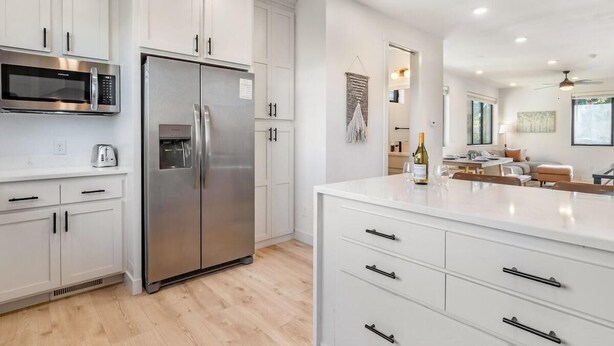 A modern kitchen with white cabinetry, stainless steel appliances, and a central island. - Fraser Ridge Retreat | 3BR/3.5BA, Free WP Shuttle (Fraser)