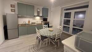 A compact kitchen with a dining table, chairs, and a microwave. - Cozy retreat near Saturnia Hot Springs with lovely views and space for 7 guests! (Manciano)