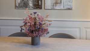 A dining area with a table, chairs, a vase of flowers, and a hanging light fixture with multiple bulbs. - Porta Portese Palace near Trastevere (Roma)