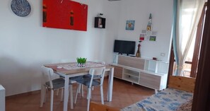 Un espace repas comprenant une table, des chaises et un téléviseur.