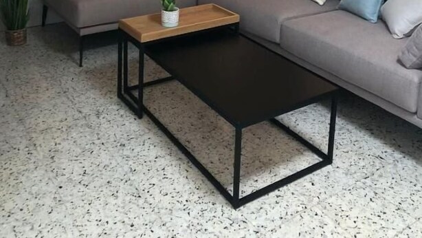 Moderni olohuone, jossa on kulmasohva, puinen sohvapöytä ja ruukussa oleva huonekasvi.