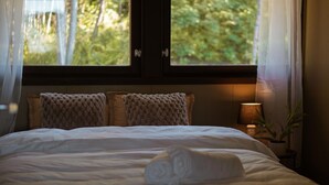 A neatly made bed with a rolled towel, two textured pillows, and a bedside lamp. - Top Floor Apartment with Scenic Views (Tromsø)