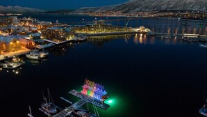 A waterfront marina with docked boats and a colorful floating structure. - Top Floor Apartment with Scenic Views (Tromsø)