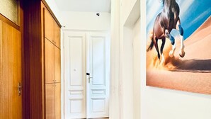 A hallway with wooden flooring, white doors, and a large painting of a horse on the wall. - Comfortable 5BR Stay Near Westbahnhof (Vienna)