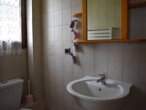 A bathroom with a white sink, a toilet, and a mirror above the sink. - Comfortable 2-room apartment - 4 people - Garden in Font-Romeu (Font-Romeu-Odeillo-Via)