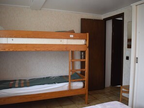 A bunk bed with a ladder, a wooden chair, and a door in a room with tiled flooring. - Comfortable 2-room apartment - 4 people - Garden in Font-Romeu (Font-Romeu-Odeillo-Via)