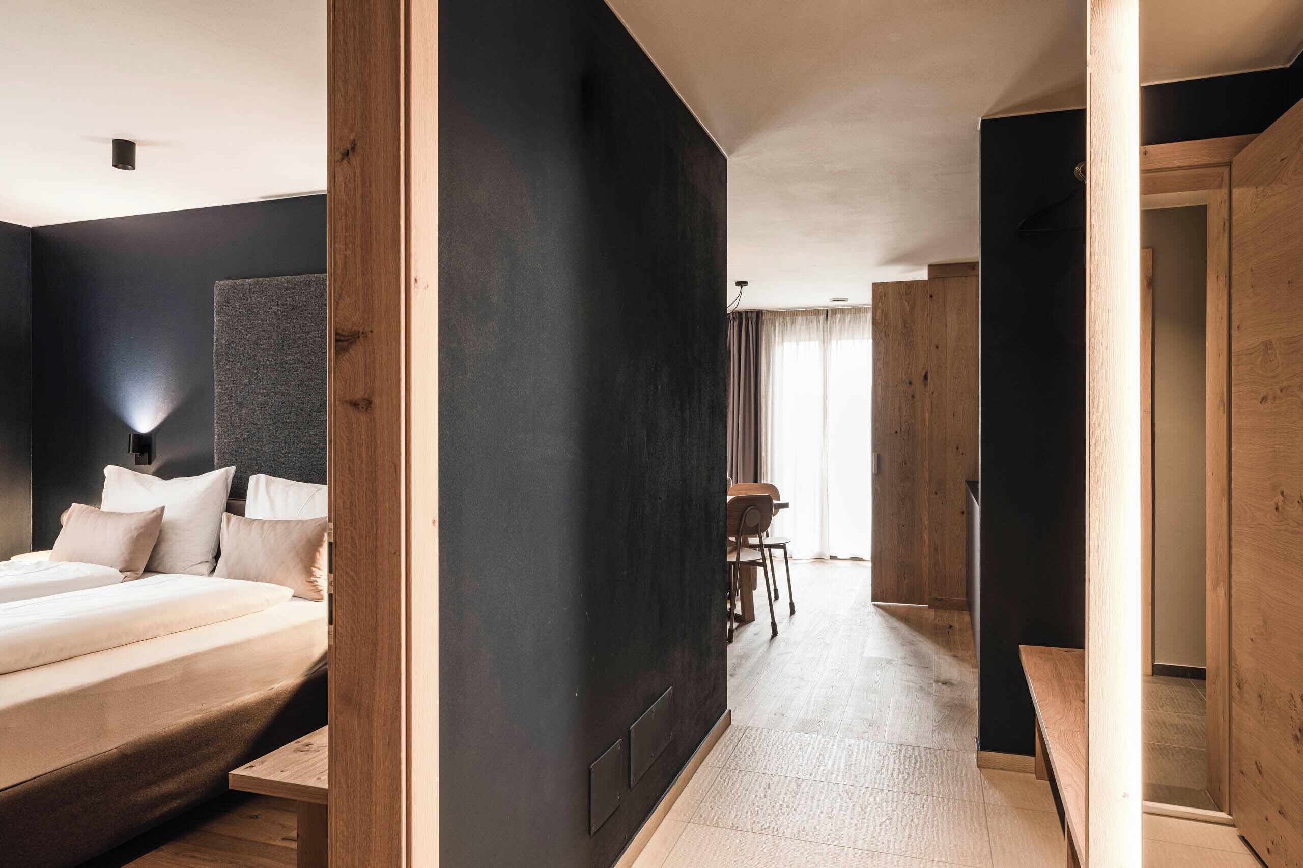 Un hotel moderno con una cama grande, un escritorio y vista al pasillo.