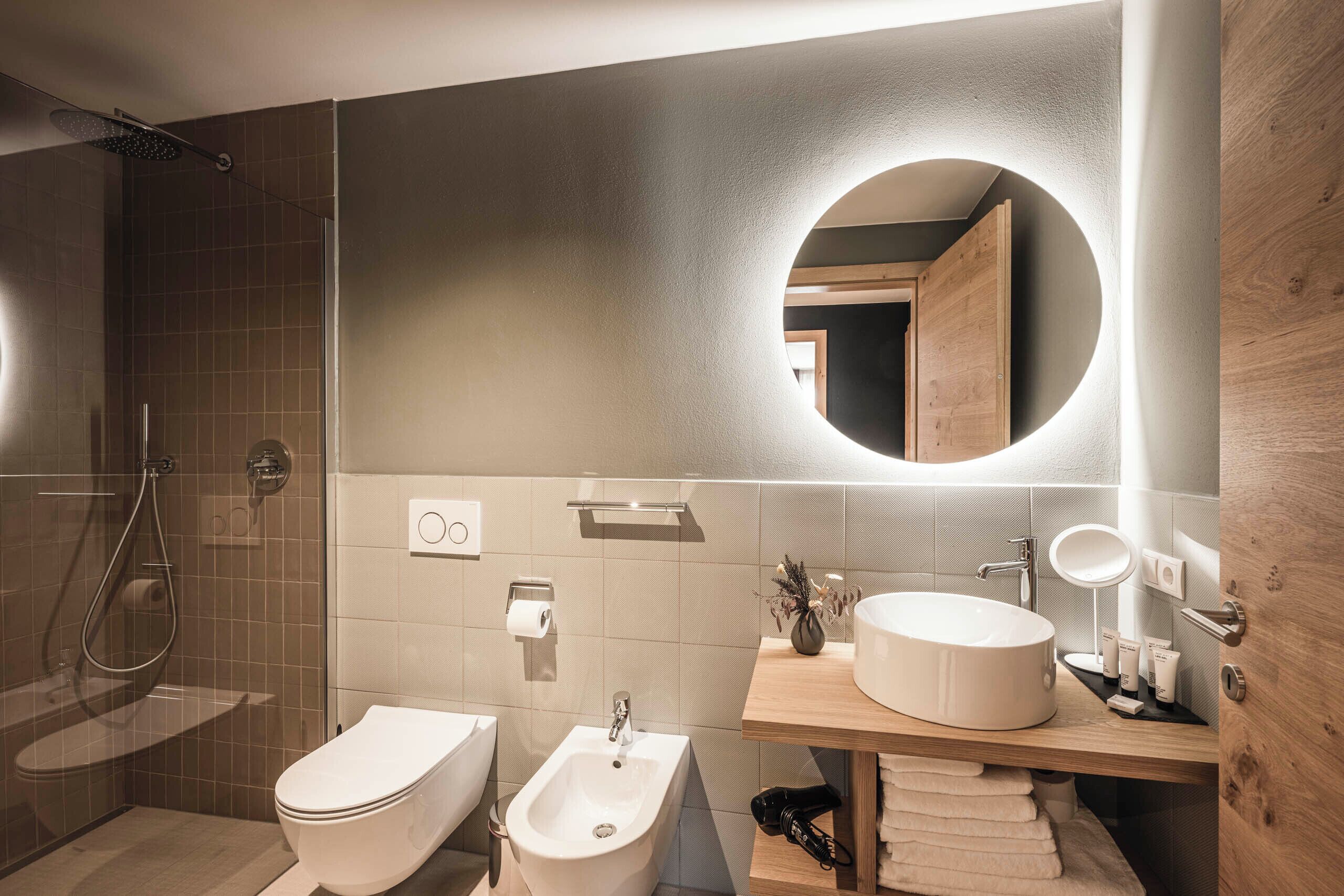 Un baño moderno con bidé, inodoro y lavamanos.