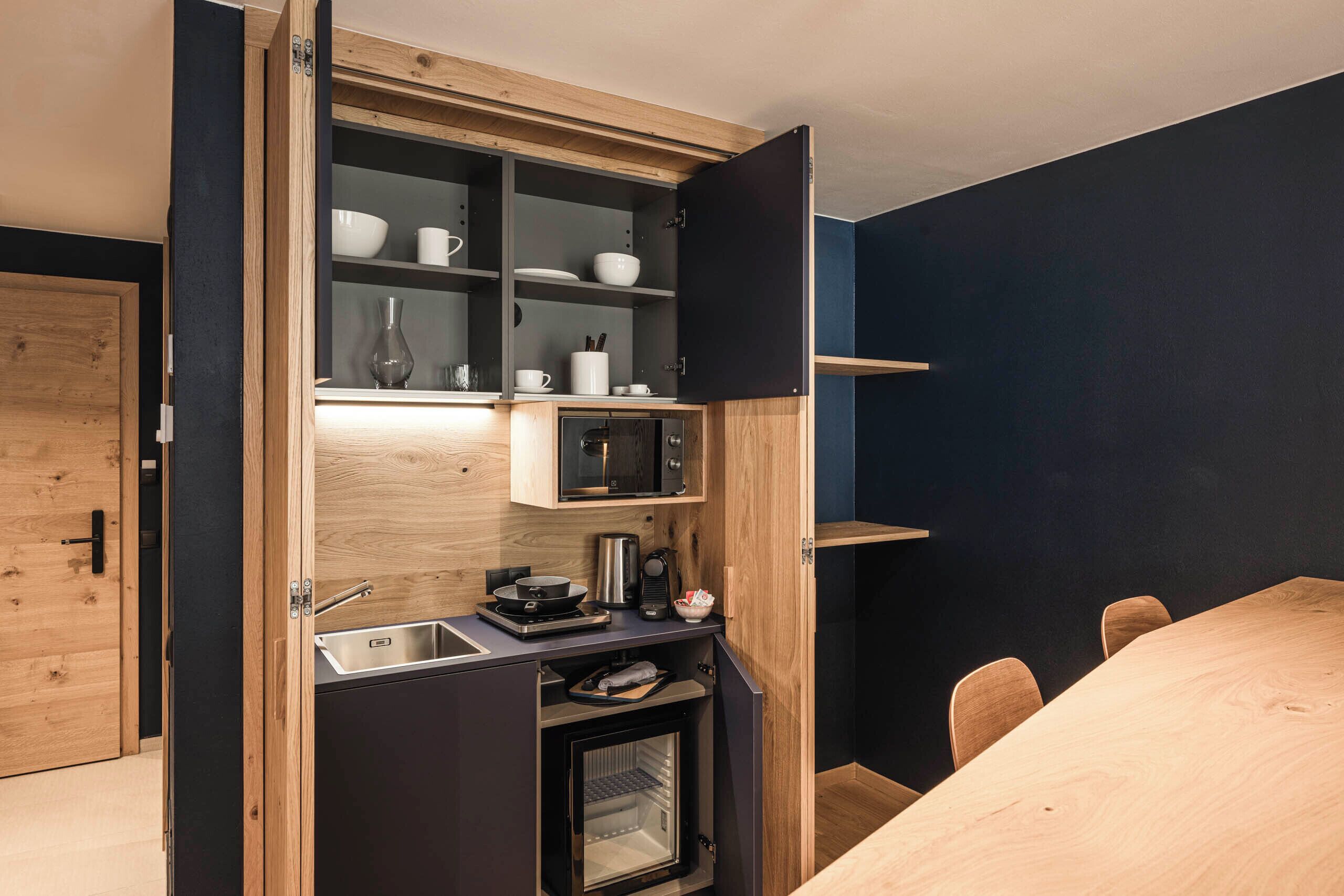 Une cuisine compacte dotée d’appareils électroménagers intégrés, d’un four à micro-ondes et d’un petit four.