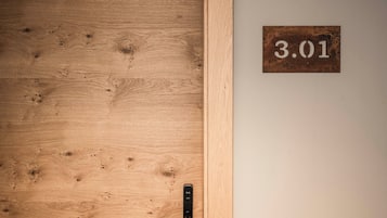 Una puerta de madera con una placa metálica que indica el número "3.01" y un picaporte moderno.