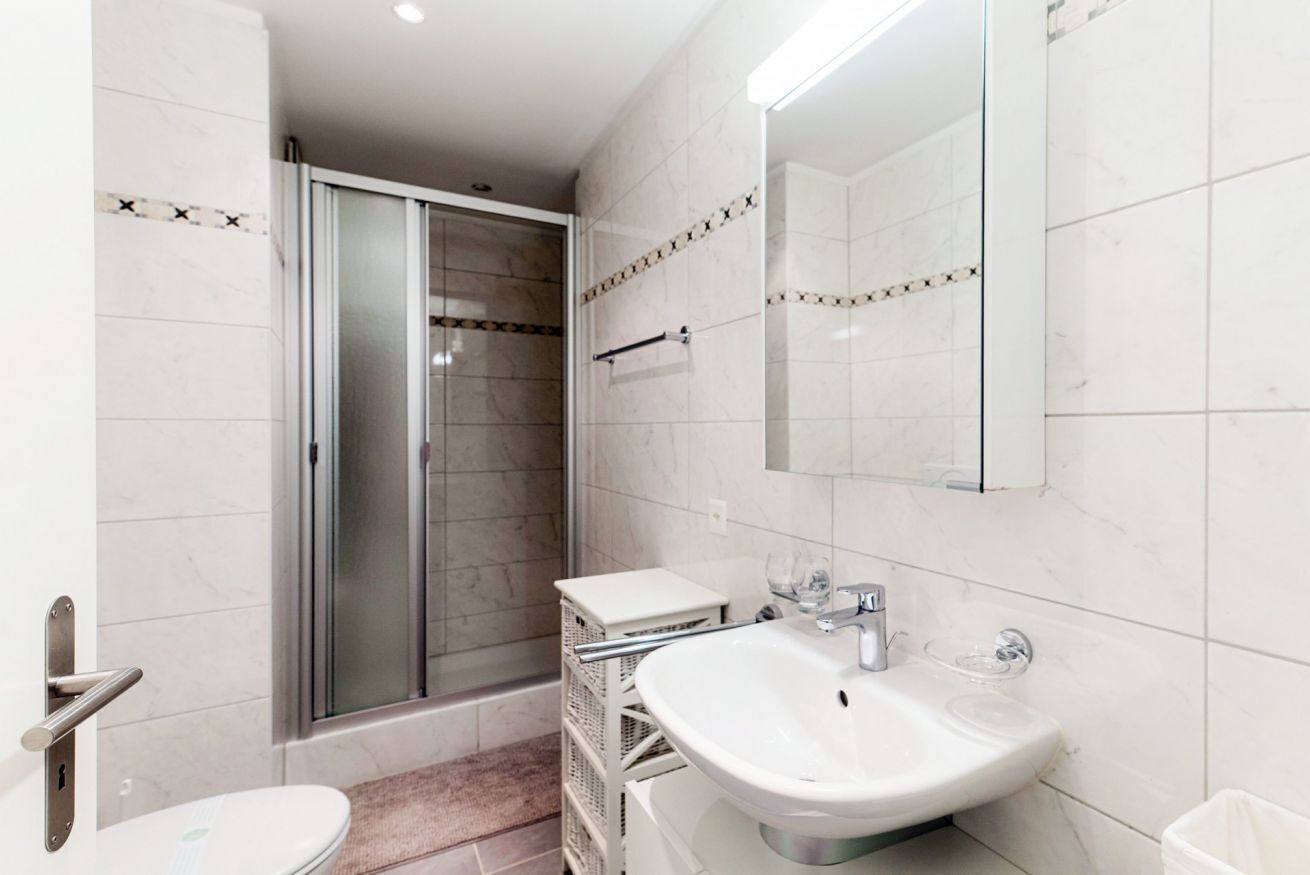 A bathroom with a shower, toilet, and sink.
