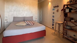 A bedroom with a bed, a nightstand, a shelf with books, and a wall with pictures. - Rooms within 15 minutes' drive of Cinque terre station and the sea (Vezzano Ligure)