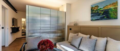 A modern living room with a sofa, a coffee table, and a painting on the wall.