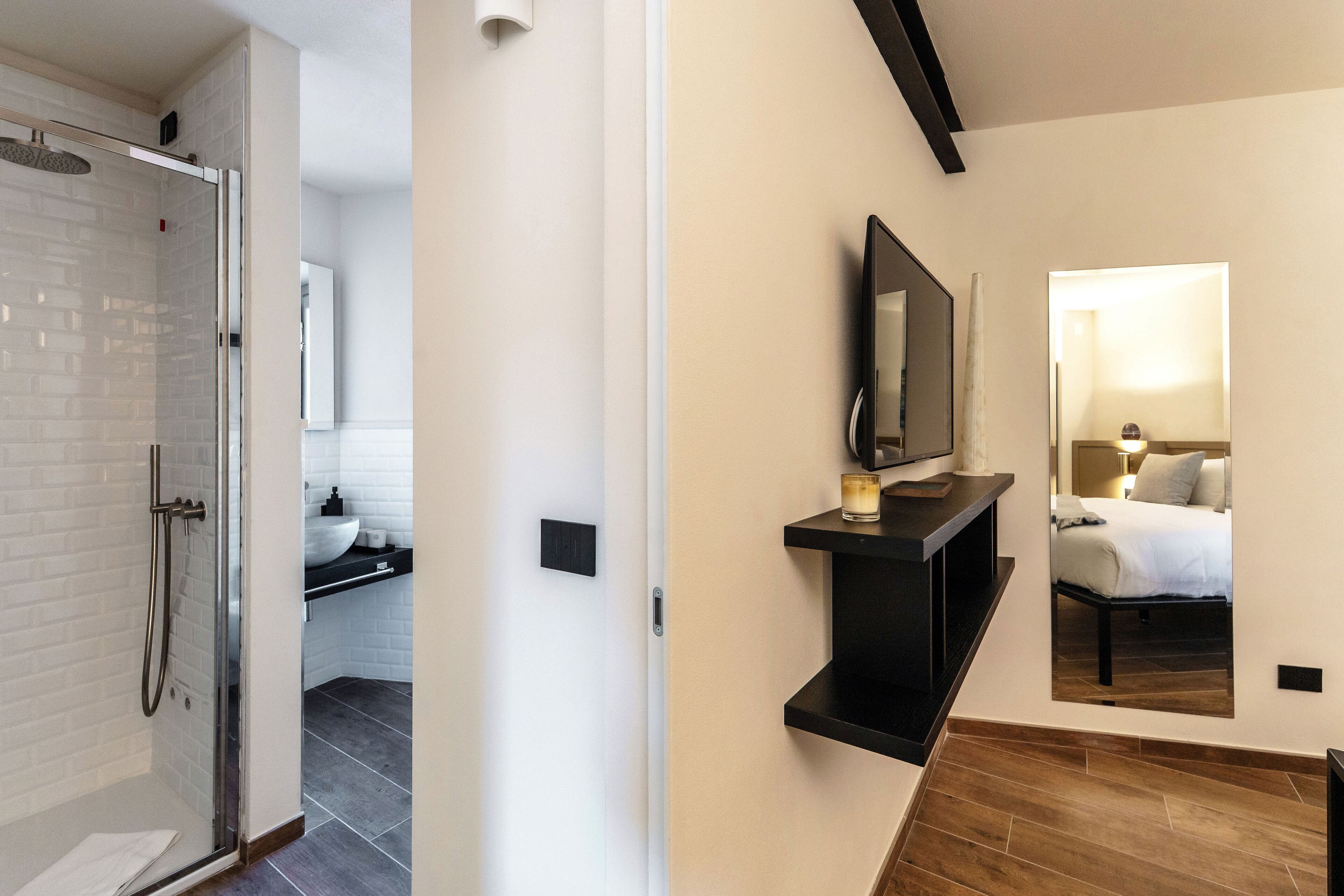 A modern bathroom with a glass shower, a sink, and a mirror.
