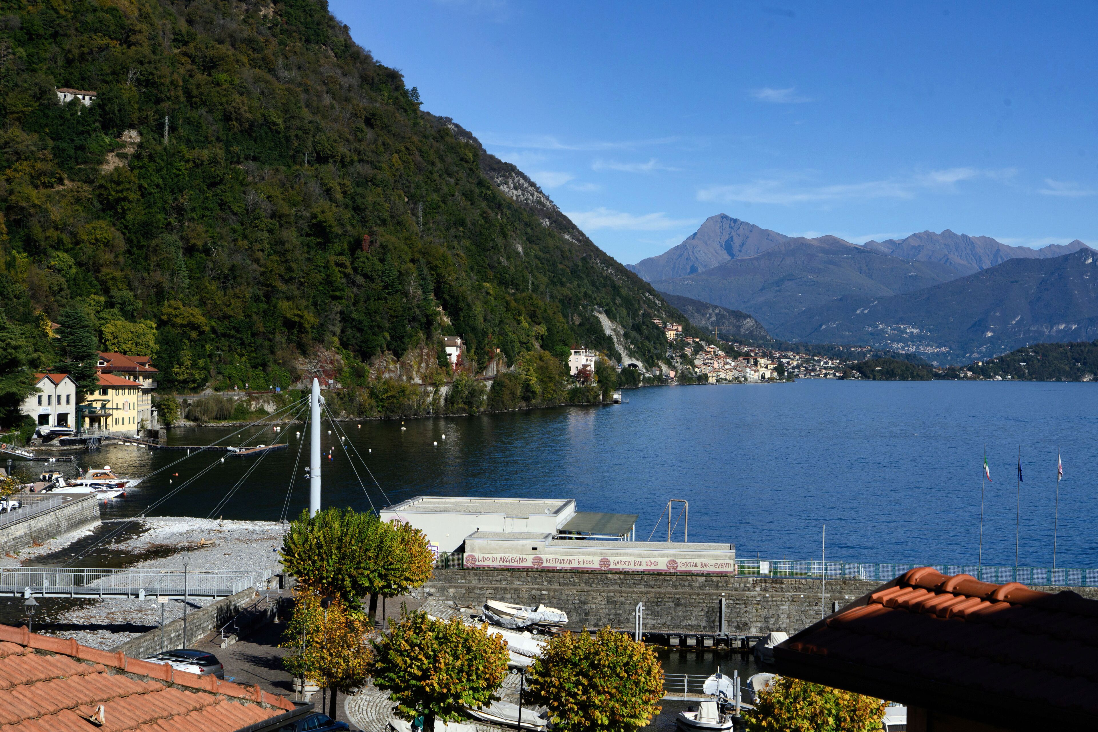 Ein Hotel am Wasser mit Blick auf einen See und Berge.