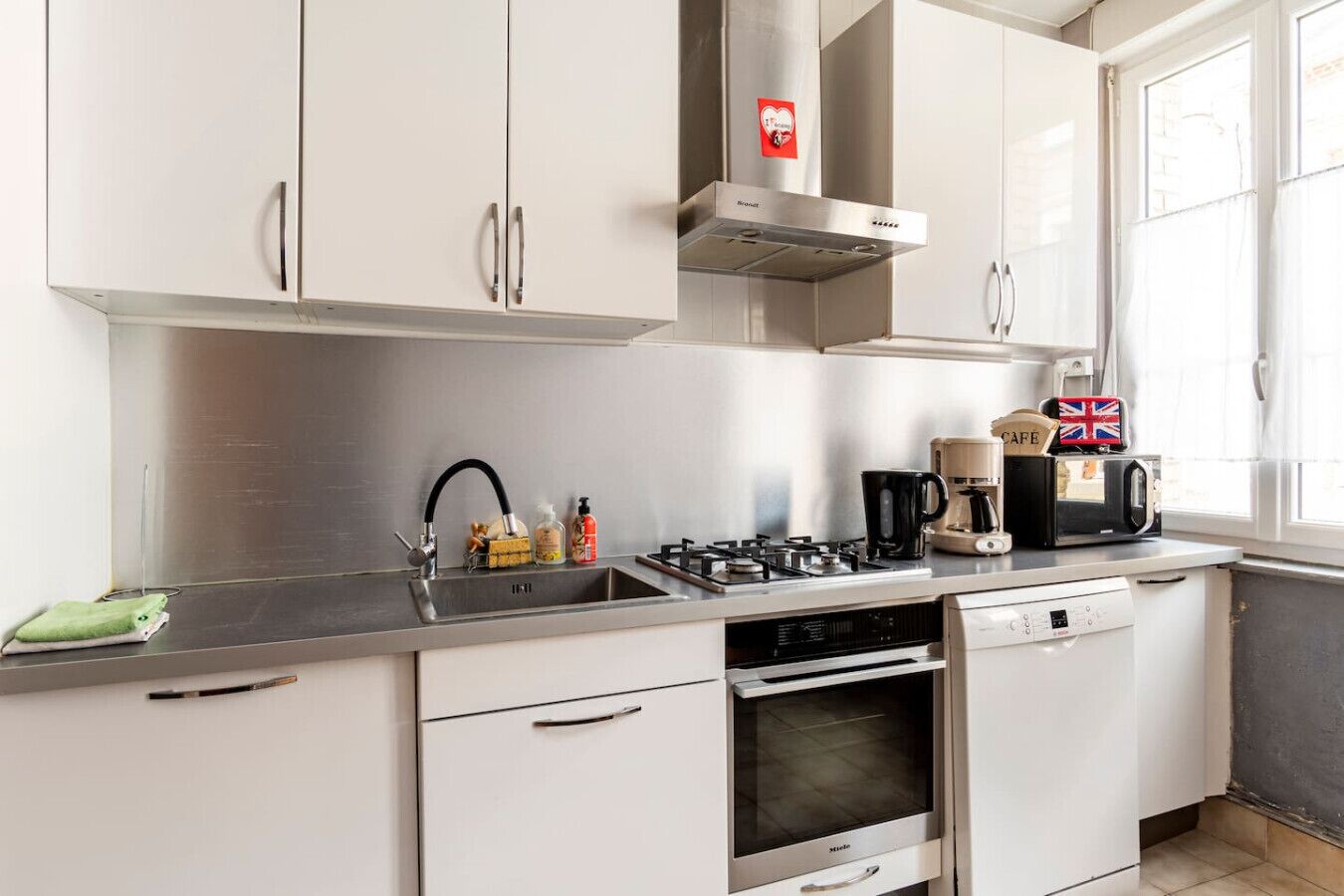 A modern kitchen with stainless steel appliances, a gas stove, a built-in oven, and a dishwasher.