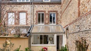 Una casa de dos pisos con un pequeño jardín delantero.