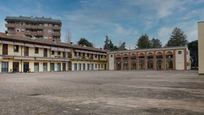 Un patio con un edificio que tiene varios balcones y un suelo de baldosas.
