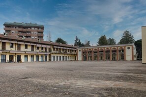 Ein Innenhof mit einem Gebäude, das mehrere Balkone und ein gefliestes Erdgeschoss aufweist.