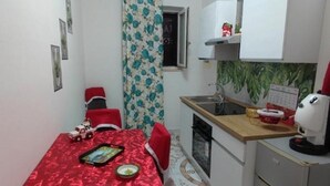 A compact kitchen with a dining area, a small refrigerator, and a sink. - Villa Pompeii Oasis (Torre Annunziata)