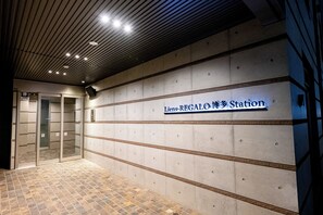 Een station met een betegelde vloer en een bord met de tekst 'Liens-REGALO Station'.