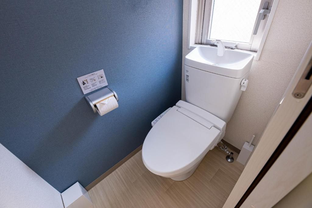 Ein kleines Badezimmer mit Toilette, Waschbecken und Fenster.
