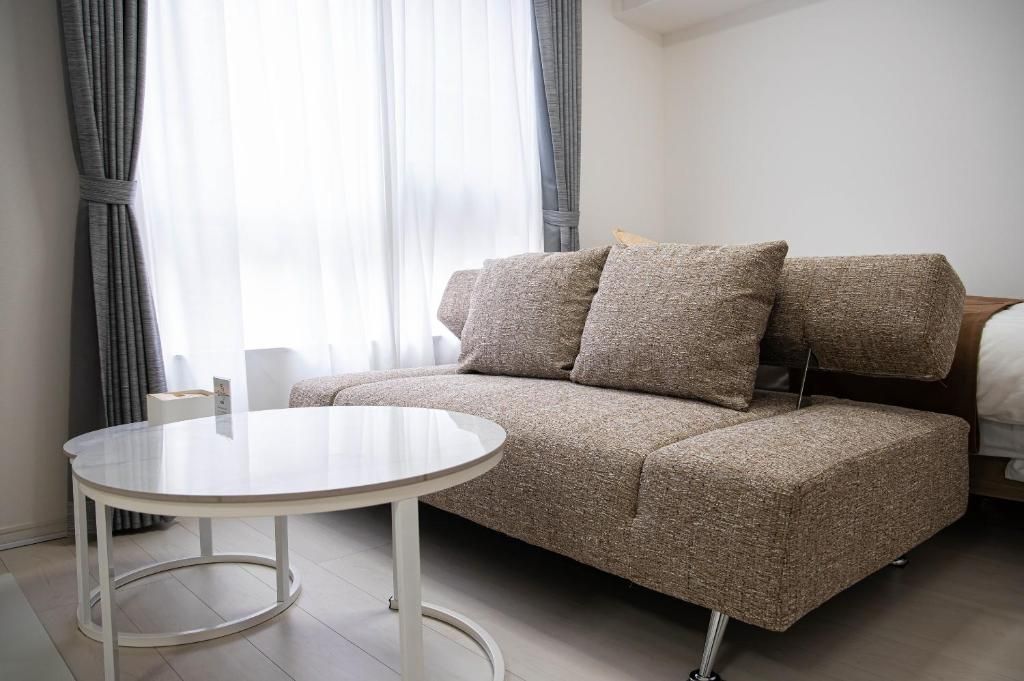 Habitació moderna amb un sofà, una taula rodona i un llit.