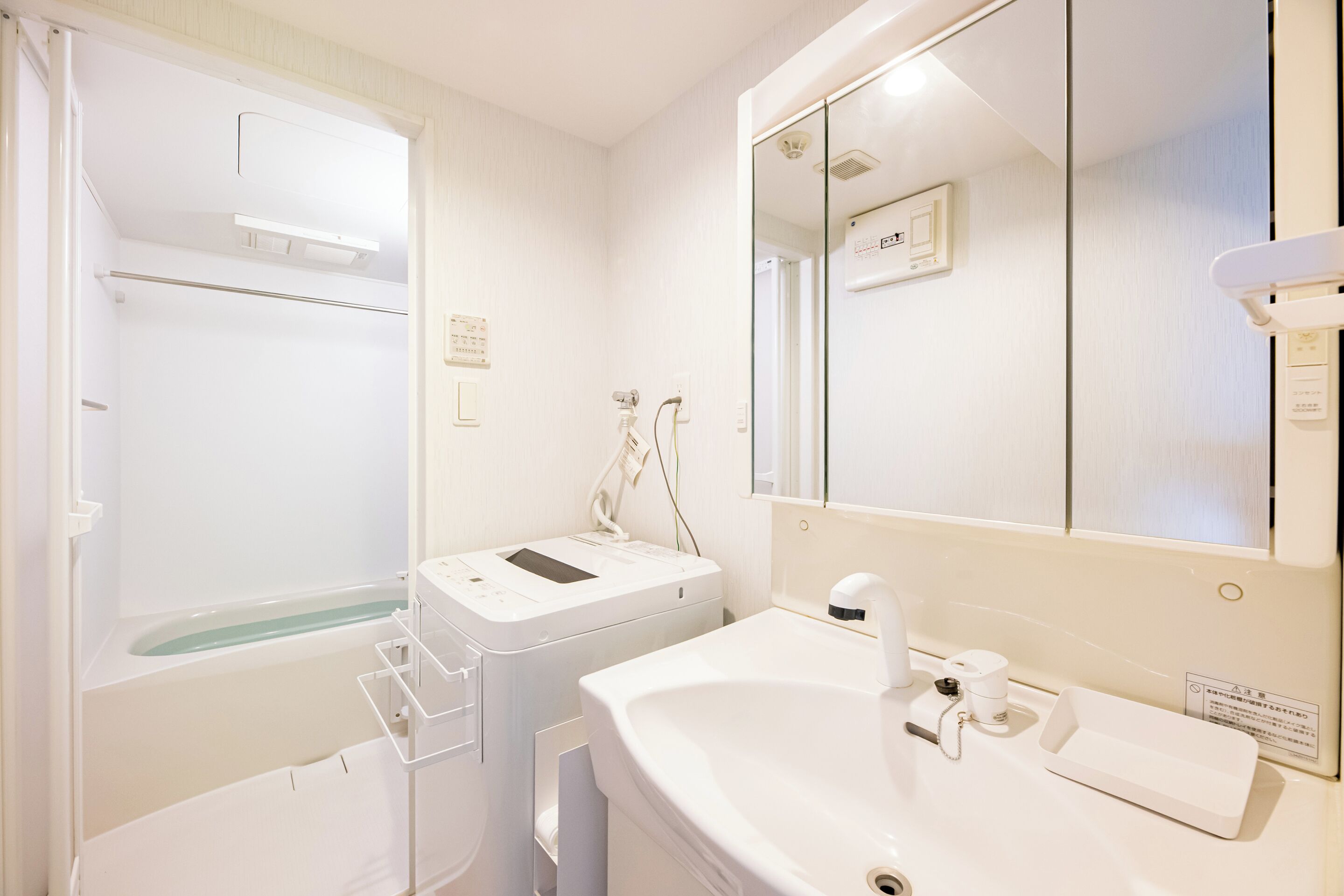 A bathroom with a bathtub, a sink, and a mirror.