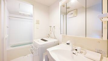 A bathroom with a bathtub, a sink, and a mirror.