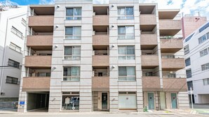 A multi-story residential building with a uniform facade, multiple balconies, and a ground-level entrance. - SPAZIO 6 Hakata Station (Fukuoka)