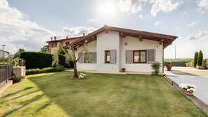 A modern house with a well-maintained lawn, a large potted plant, and a clear sky. - Villa Il Fico – Cavriglia: Relax in the Heart of Chianti (Cavriglia)