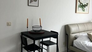 Ett modernt vardagsrum med en matplats, inrett med en soffa, ett matbord med stolar och två inramade konstverk på väggen.