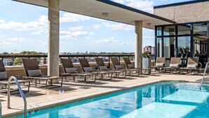 A rooftop pool with lounge chairs and a view of the city skyline. - 1-bedroom in Arlington, DC metro area with on-site parking included (Arlington)
