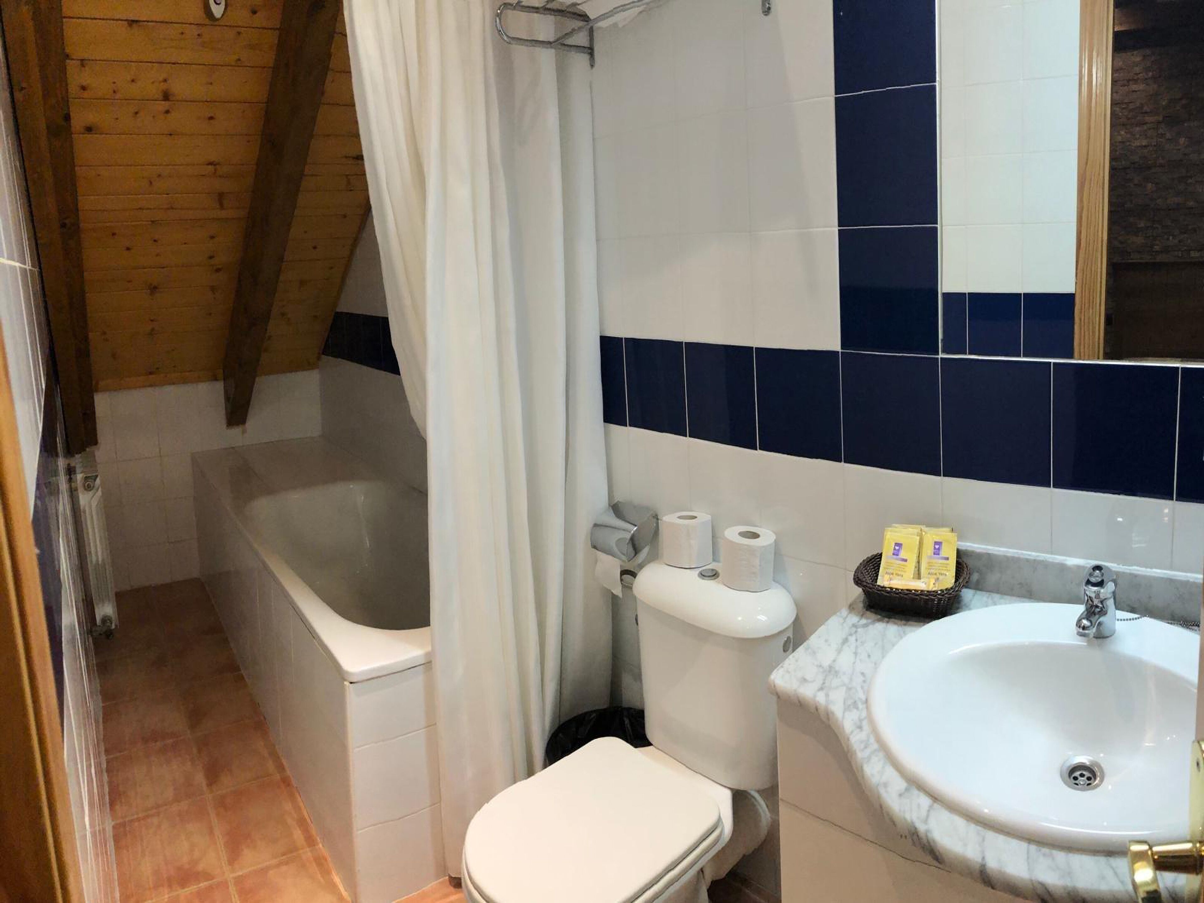 A bathroom with a bathtub, toilet, and sink.