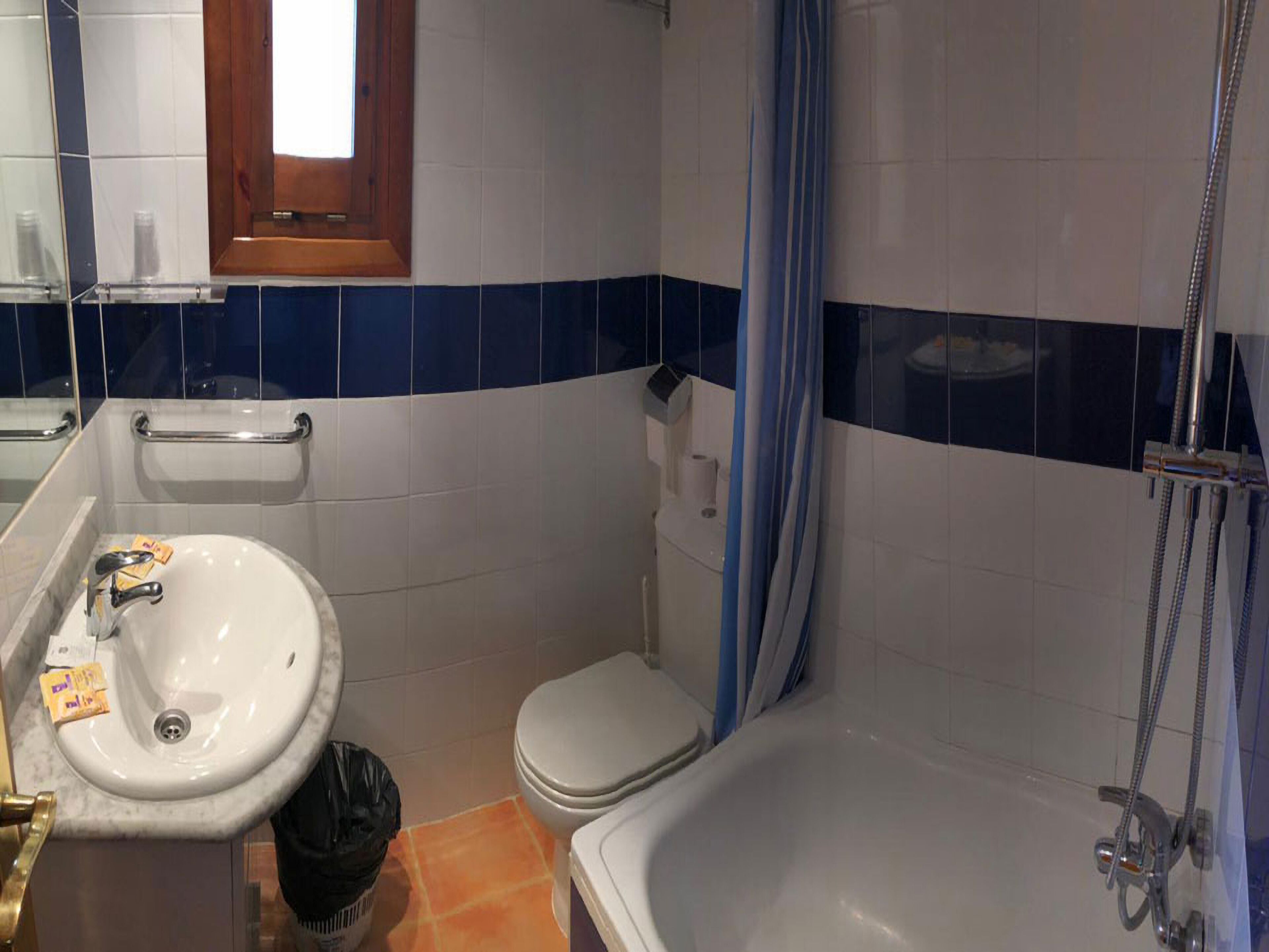 A bathroom with a sink, toilet, and bathtub.