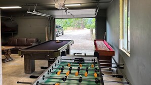 Une pièce équipée d’une table de billard, d’un baby-foot et d’un téléviseur.