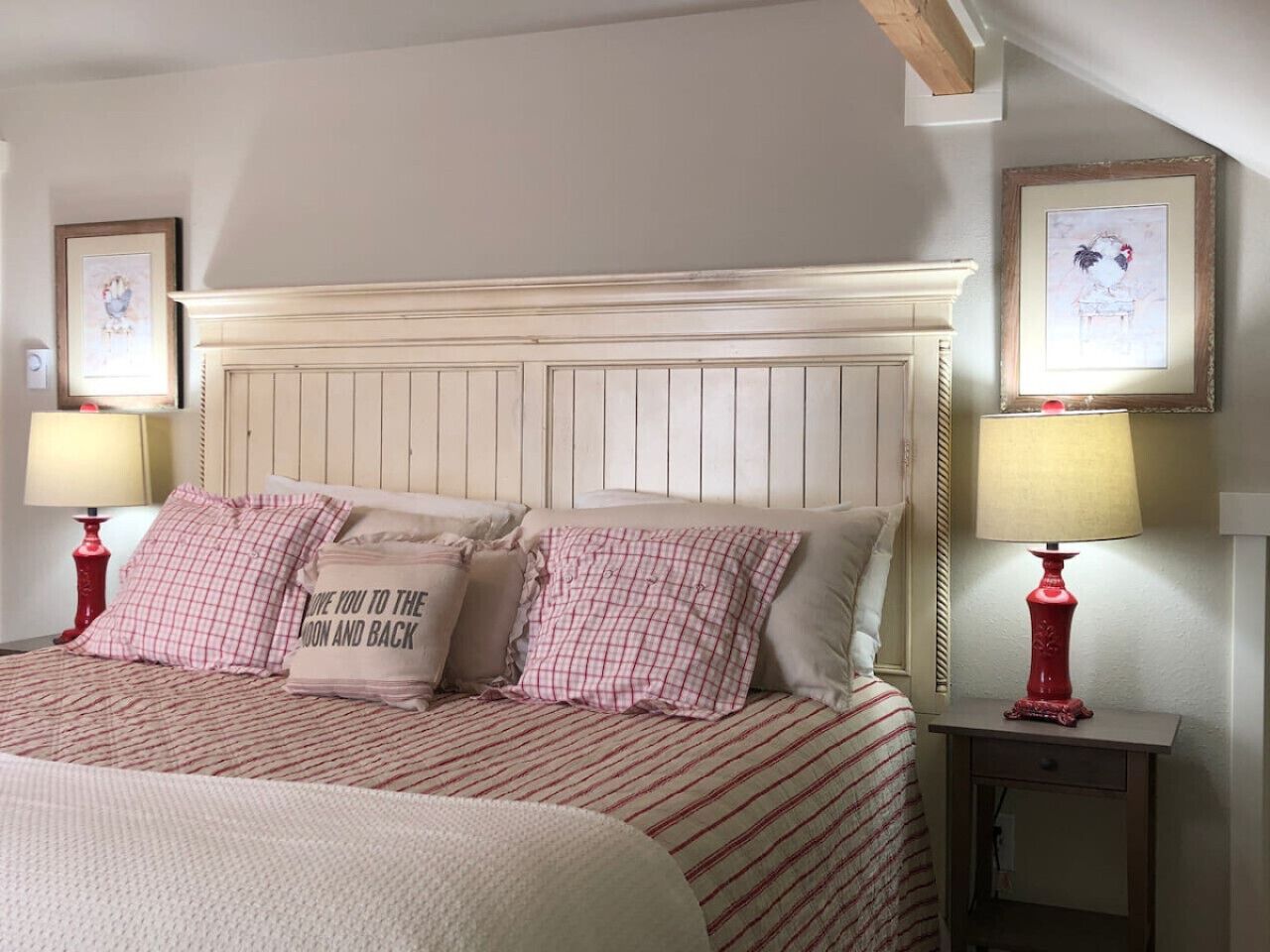 A bedroom with a bed, two bedside tables, a headboard, and two wall-mounted lamps.