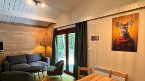 Une pièce avec un plafond en bois, un canapé, une table à manger et des chaises.