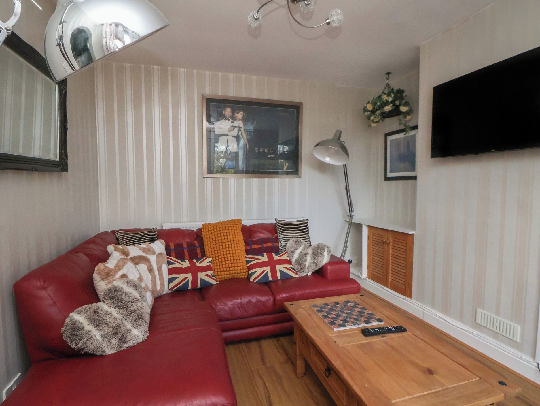 A living room with a red sofa, a wooden coffee table, and a framed picture on the wall.