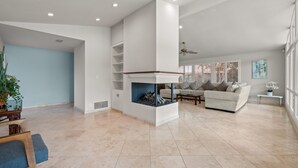 A spacious living room with a fireplace, a sofa, and a coffee table. - Bright Family Getaway Large Backyard Oasis Patio (Santa Ana)