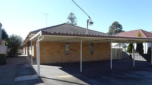 A covered patio area with a brick building, a concrete floor, and a clear sky. - Prickly Pear Stays in Adamstown, 1-br (Newcastle)