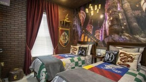 A hotel room with two beds, a brick wall, a large mural, and a window with red curtains. - Summerville Resort 5 Bedroom Vacation Home 2620 (Kissimmee)