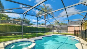 A swimming pool with a hot tub, surrounded by a covered area with a view of a residential neighborhood. - Peaceful Clermont Gem w/ Pool, 9 Mi to Disney! (Clermont)
