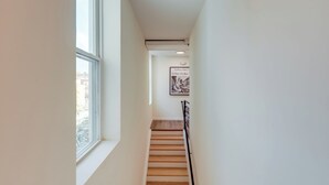 A narrow stairway with a wooden handrail, a window on the left, and a framed picture on the wall. - 1 Mi to University of Cincinnati: 3rd-floor Condo! (Cincinnati)